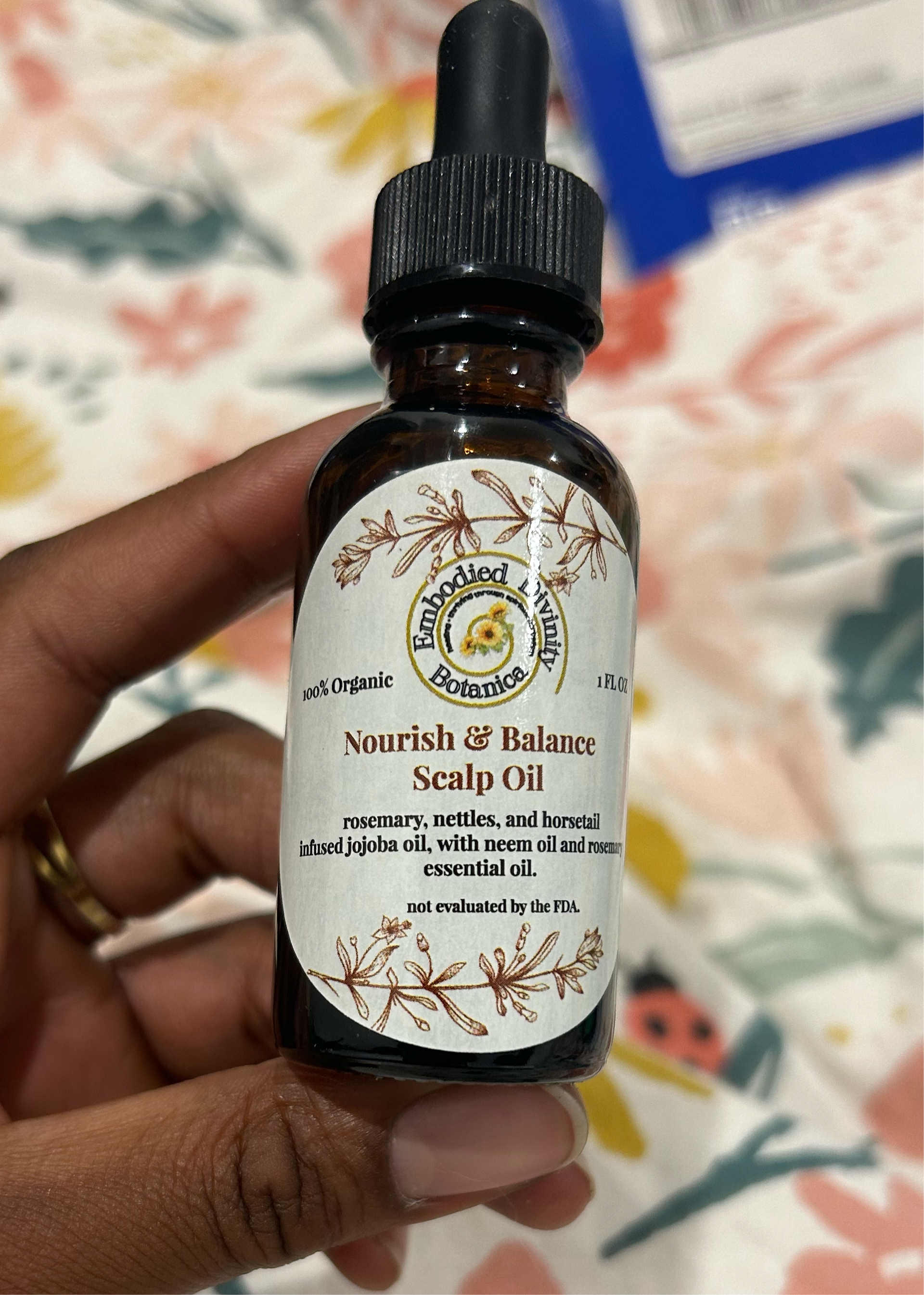 Amber ropper bottle of Nourish + Balance scalp oil with label, used for hair growth and scalp care