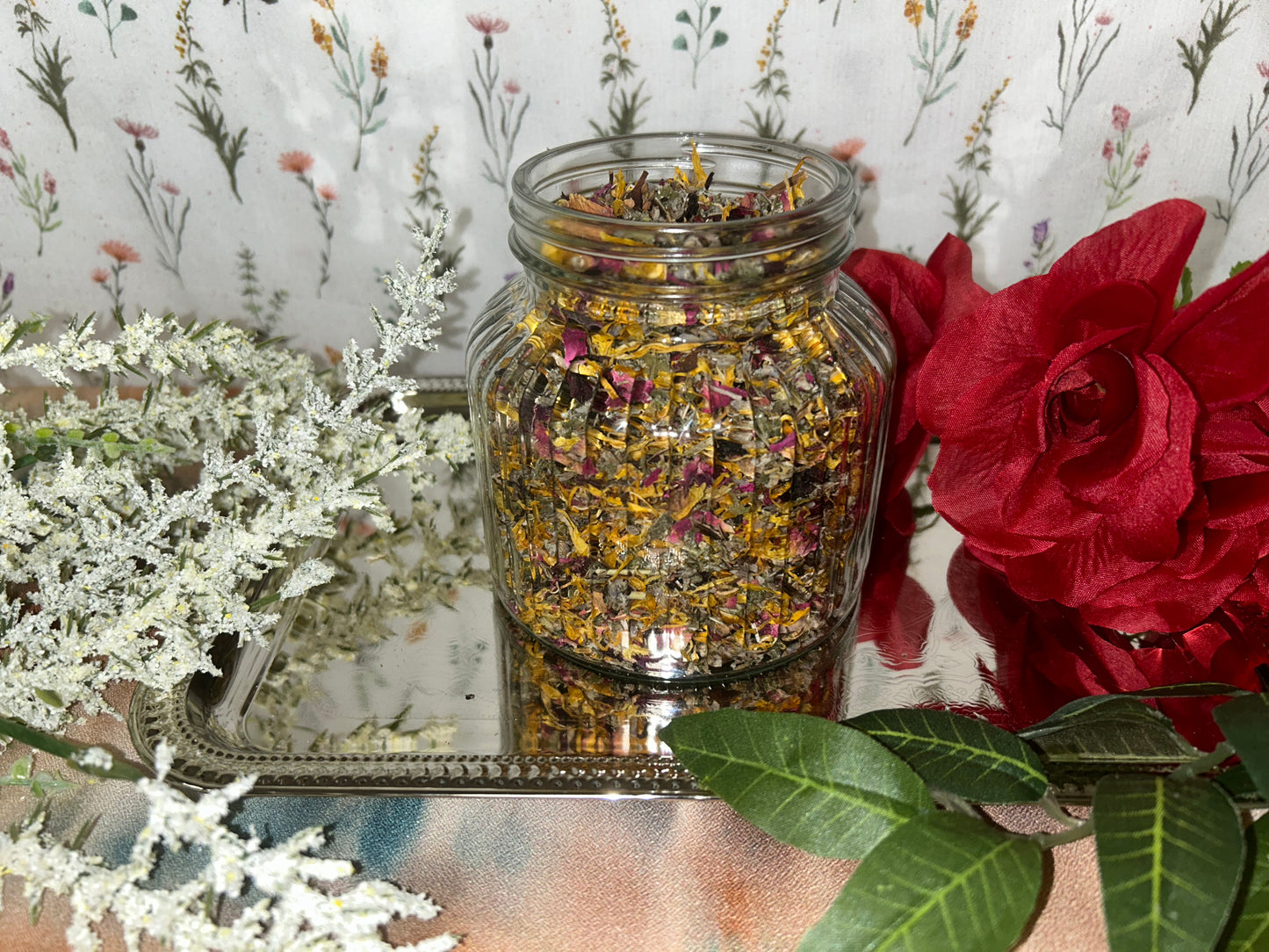 Glass jar of dried organic tea blend of of red raspberry leaf, lavender, plantain leaf, hibiscus, rose, mugwort, and calendula for vaginal steaming